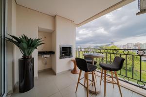 um quarto com uma varanda com uma mesa e cadeiras em 802 Maison Duplex para pessoas de bom gosto. em Joinville