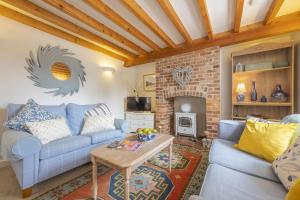 a living room with a blue couch and a fireplace at Seaview Cottage in Hunstanton