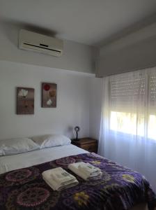sypialnia z łóżkiem z dwoma ręcznikami w obiekcie Posada de Britopolis w mieście Colonia Valdense