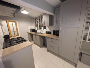 una cucina con armadi grigi e piano cottura. di Airfield Manor a Castle Donington