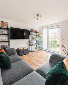 a living room with a couch and a flat screen tv at Stunning 1 BD flat in Lochend Park with a patio in Edinburgh