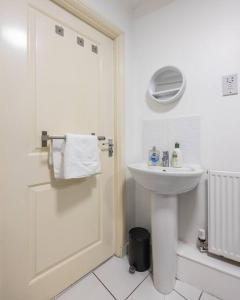 a white bathroom with a sink and a shower at Stunning 1 BD flat in Lochend Park with a patio in Edinburgh