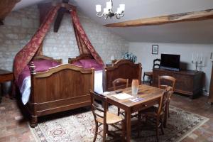 a bedroom with two beds and a table and a dining room at Chez Florence et Sylvain de Loudun in Loudun