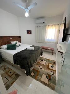 a bedroom with a bed and a television and a rug at Vila Pepira ViP in Brotas