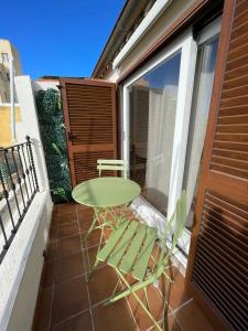 einen grünen Tisch und einen Stuhl auf dem Balkon in der Unterkunft Excellent Rooms Paola's in Olbia