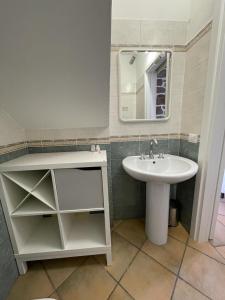 ein Bad mit einem Waschbecken und einem Spiegel in der Unterkunft Excellent Rooms Paola's in Olbia