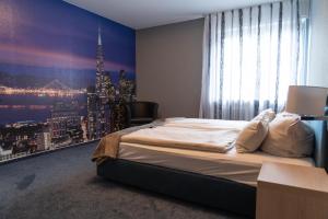 a bedroom with a large window with a view of a city at Hotel-Restaurant Kolpinghaus in Lingen +35 photos