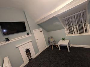 uma sala de estar com lareira e uma televisão de ecrã plano em Airfield Manor em Castle Donington