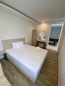 una camera da letto con un grande letto bianco e uno specchio di Coral Boutique Apartments a Ofrínion