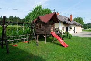 une aire de jeux avec toboggan et une maison dans l'établissement Apartma Marija, à Metlika