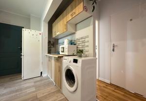 a kitchen with a washing machine and a refrigerator at Panda Room in Gdynia