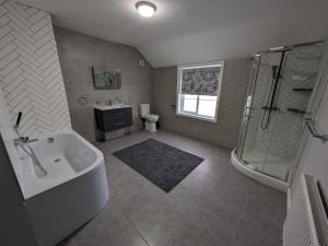 bagno con vasca, doccia e lavandino di Airfield Manor a Castle Donington