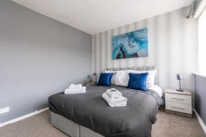 um quarto com uma cama grande e toalhas em 3 Bed Apartment - Perfect for Contractors near Liverpool Airport em Hale