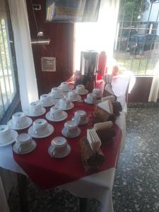 una mesa con tazas blancas y platos en ella en Lomita Gesell en Villa Gesell