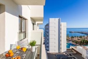 a balcony with a table with fruit and orange juice at Ocean House 1713 By IVI Real Estate in Torremolinos