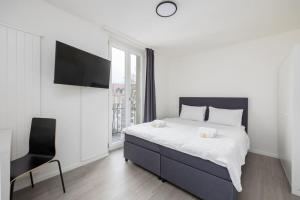 Dormitorio blanco con cama y silla negra en Urban Oasis with Queen Bed and View BE-49, en Zúrich