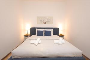 a bedroom with a large white bed with two lamps at Ruby holiday home with patio in Vienna +20 photos