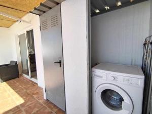a washing machine in a laundry room with a door at El Médano Gran Terraza Tenerife in El Médano