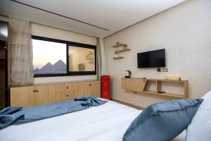 a bedroom with a bed with a window and a tv at Piccolo Mondo Boutique Hotel in Cairo