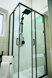 La salle de bains est pourvue d'une douche avec une porte en verre. dans l'établissement La Suerte Ercolano, à Ercolano