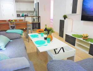 Sala de estar con sofá y mesa con botella de vino en Vacaciones Sur Tenerife Ofogar, en San Isidro