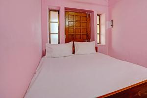 a white bed in a room with a window at OYO Hotel Neelkamal palace and Guest house in Nāthdwāra