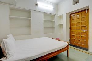 a room with a bed with shelves and a door at OYO Hotel Neelkamal palace and Guest house in Nāthdwāra