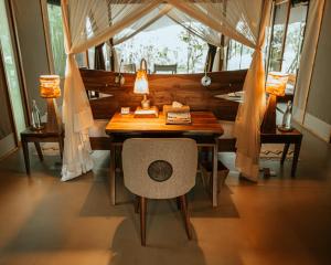 einen Schreibtisch mit Stuhl in einem Zimmer mit Fenstern in der Unterkunft Soroi Luxury Migration Camp in Sekenani