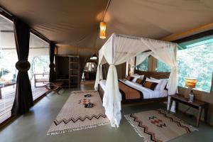 ein Schlafzimmer mit einem Himmelbett in der Unterkunft Soroi Luxury Migration Camp in Sekenani