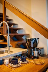 a kitchen counter with a coffee maker and two cups at 802 Maison Duplex para pessoas de bom gosto. in Joinville