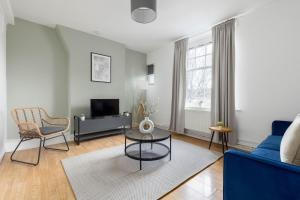 uma sala de estar com um sofá azul e uma mesa em The Shoreditch Collection em Londres
