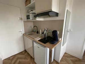 a small kitchen with a sink and a microwave at Skyview - Triel sur Seine in Triel-sur-Seine