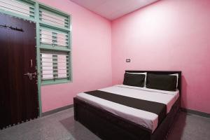 a bedroom with a pink room with a bed and a window at OYO Shree Ram Hotel & restaurant in Rewāri