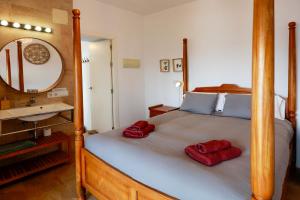 1 dormitorio con 1 cama con 2 toallas rojas en Beach Front Villa Amazing Views, en Tarifa