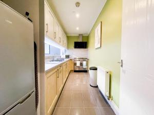 a kitchen with a sink and a refrigerator at Recently Refurbished Two Bedroom Apartment, Central Location! in Glasgow