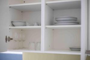 a white pantry with plates and dishes on shelves at Urban Oasis with Queen Bed and View BE-33 in Zürich