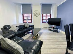 a living room with a couch and a flat screen tv at Recently Refurbished Two Bedroom Apartment, Central Location! in Glasgow