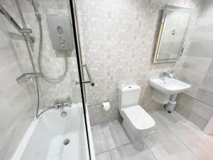 a bathroom with a shower and a toilet and a sink at Recently Refurbished Two Bedroom Apartment, Central Location! in Glasgow