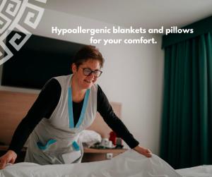 a woman in an apron making a bed at Hotel Galatea in Mladá Boleslav +37 photos