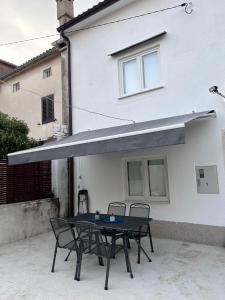 a patio with a table and chairs in front of a building at Holiday home Omišalj in Omišalj