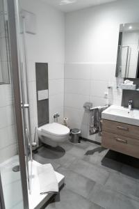 a bathroom with a toilet and a sink at Hotel-Restaurant Kolpinghaus in Lingen