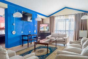 a living room with blue walls and white furniture at Sai Rock Beach Hotel & Spa in Bamburi