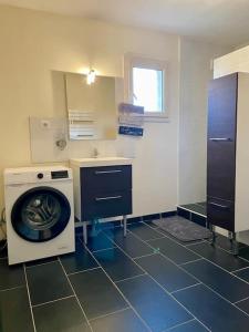 a kitchen with a washing machine and a sink at Halte à Saint Leu - Maison 5 personnes in Saint-Leu