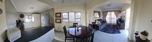 a living room with a dining room table and a kitchen at 20 Almond Rd in Kingsburgh