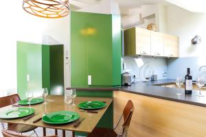 ボルドーにあるChartreuse du Parc - Appartement 2 chambres avec Parking - Caudéranのキッチン(緑のキャビネット、木製テーブル、緑の皿付)