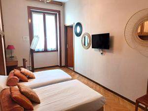 Habitación con 2 camas y TV en la pared. en Milano Brera Relais, en Milán
