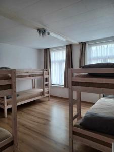 a room with three bunk beds and two windows at De Blauwer, Roesbrugge in Poperinge