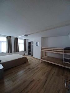 um quarto grande com uma cama e pisos em madeira em De Blauwer, Roesbrugge em Poperinge