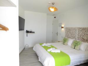 1 dormitorio con 1 cama blanca grande y toallas. en Lua Hotel Boutique, en El Pinar de El Hierro
