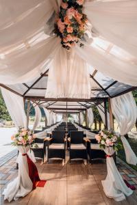 a wedding aisle with chairs and curtains and flowers at Honour and Grace Hotel in Jáchymov